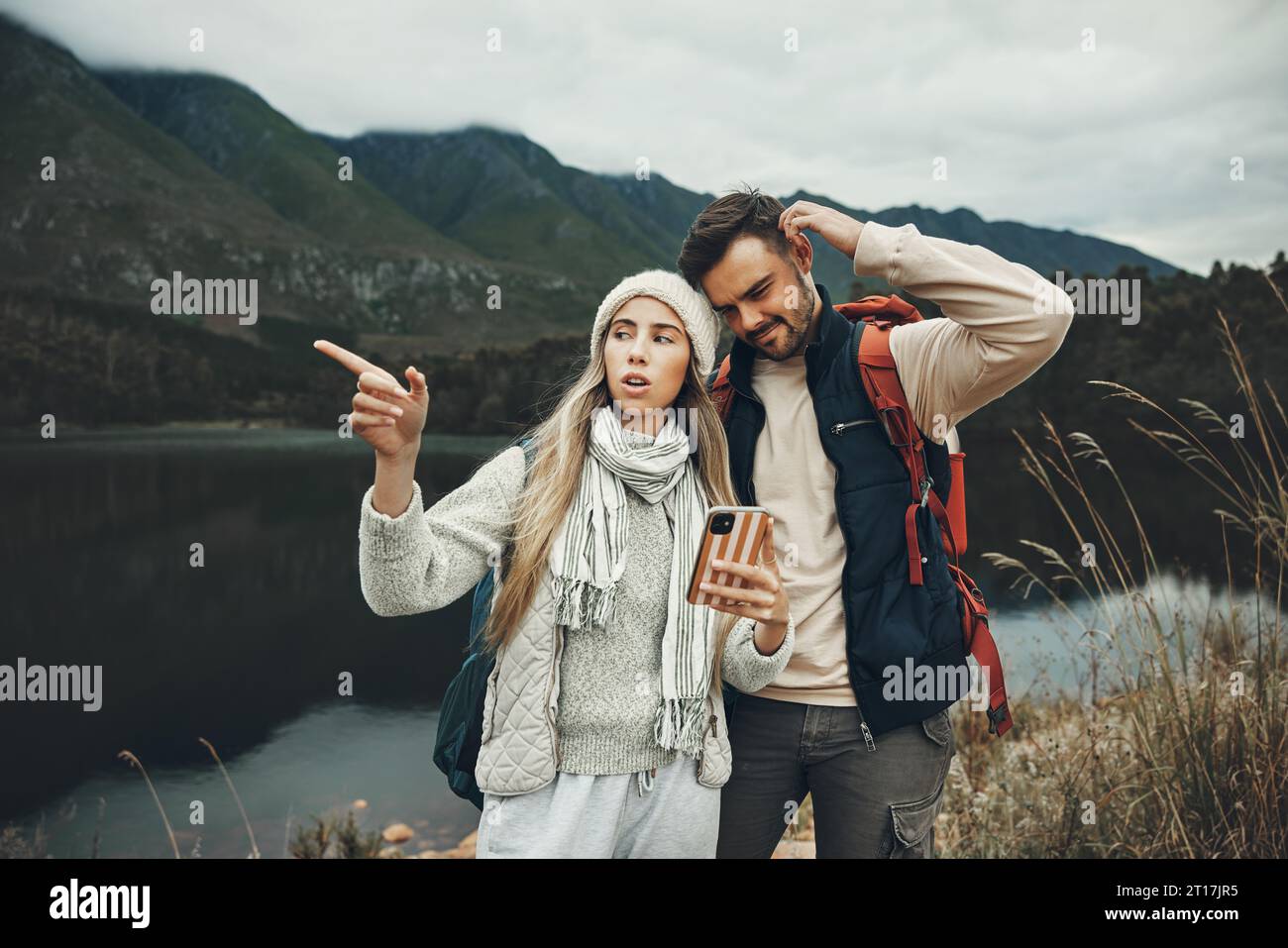 Wandern, Stress und verlorenes Paar mit einem Telefon in der Natur für Richtung, Karte oder Navigation mit Angst. Rucksackreisen, Reisen und Menschen mit Smartphone Stockfoto
