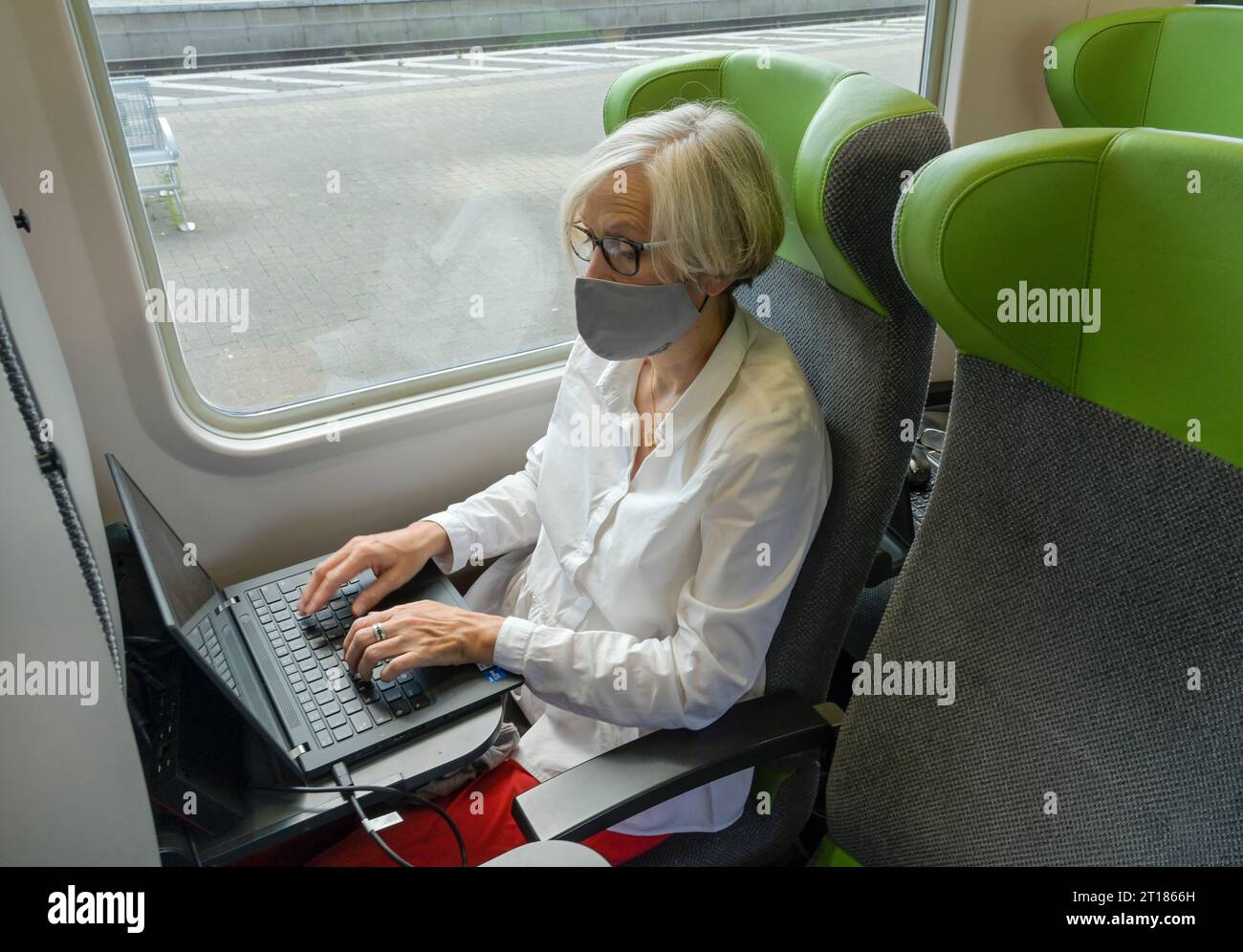 Frau mit Mundschutz, Laptop, Flixtrain Stockfoto