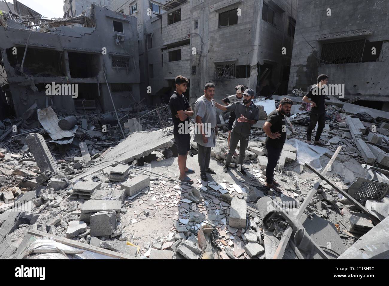 Gaza-Stadt. Oktober 2023. Menschen werden um zerstörte Gebäude und ...