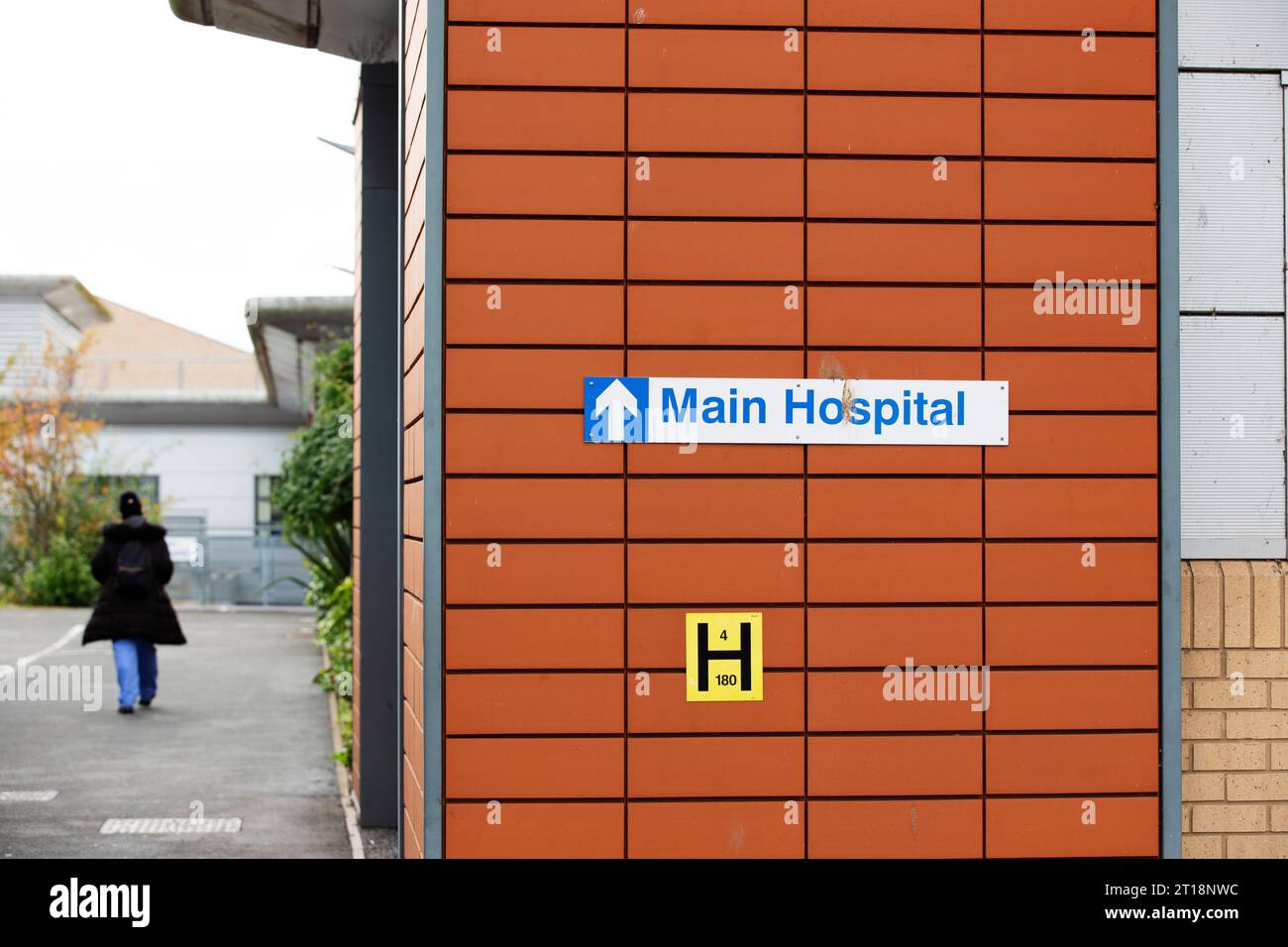 Krankenhaus NHS Personal/Krankenschwester gehen in die Arbeit hinter dem Hauptkrankenhausschild in Exeter Krankenhaus R D & E Stockfoto