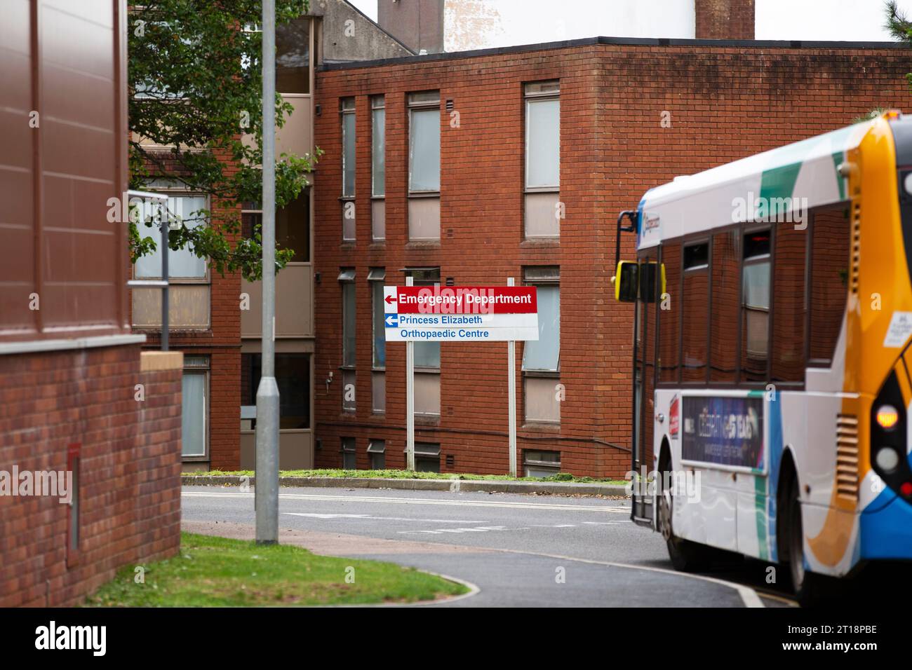 Postkutschenbus fährt bis zum Schild der Red Emergency Department am Royal Devon & Exeter Hospital Stockfoto