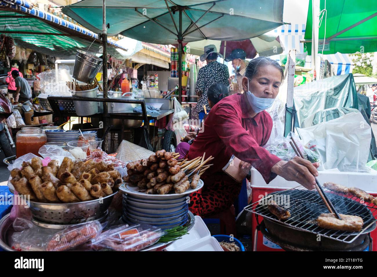 Binh Tay Marktszene, Vendor Brasting Meat over Charcoal, Ho Chi Minh City, Vietnam. Stockfoto