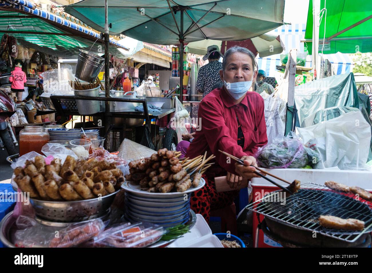 Binh Tay Marktszene, Vendor Brasting Meat over Charcoal, Ho Chi Minh City, Vietnam. Stockfoto