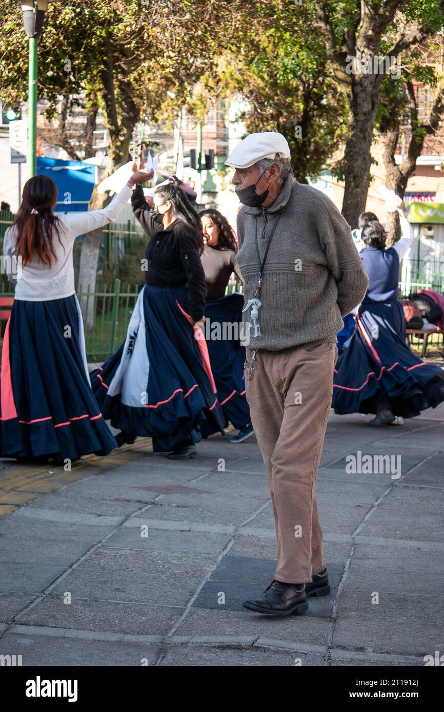 La Paz, Bolivien - 8. August 2022: Alter Mann trägt eine schwarze Maske unter der Nase und eine Flasche Desinfektionsalkohol, die an seinem Hals hängt Stockfoto