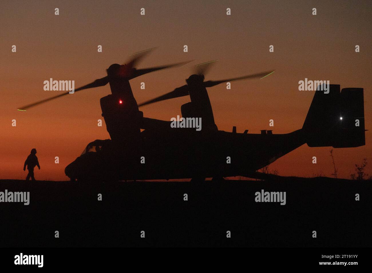 Oceanside, Usa. 26. September 2023. Ein US-Marine mit 1. Aufklärungsbataillon geht auf ein USMC MV-22 Osprey-Kipprotor-Flugzeug zu, das der mittleren Tiltrotor Squadron 164 zugewiesen ist, während es sich vorbereitet, bei Sonnenuntergang während einer gemeinsamen Aufklärungsübung mit der Royal Australian Army im Marine Corps Base Camp Pendleton abzuheben, 26. September. 2023 in Oceanside, Kalifornien. Quelle: Sgt. Amanda Taylor/USA Marine Corps/Alamy Live News Stockfoto
