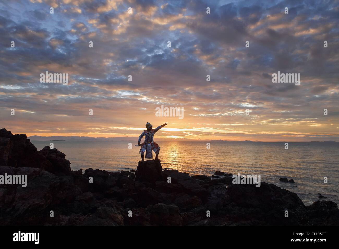 Maskierte Khon-Tänzerin, die bei Sonnenuntergang am Strand auftritt, Thailand Stockfoto