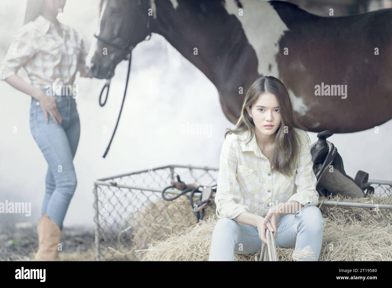 Zwei Frauen und ein Pferd in einem Stall, Thailand Stockfoto