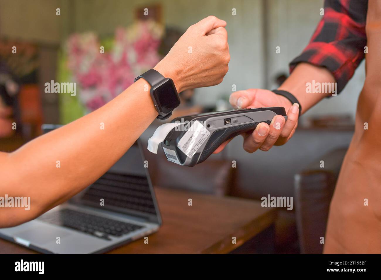 Frau, die kontaktlos mit einem Kreditkartenleser bezahlt, mit einer Smart Watch Stockfoto