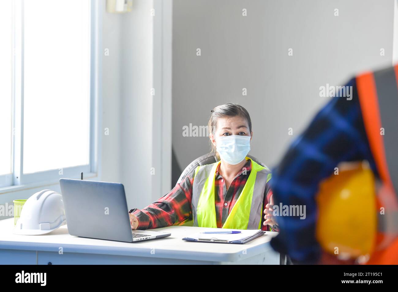 Zwei Bauinspektoren in einem Büro, die ein Bauprojekt diskutieren Stockfoto