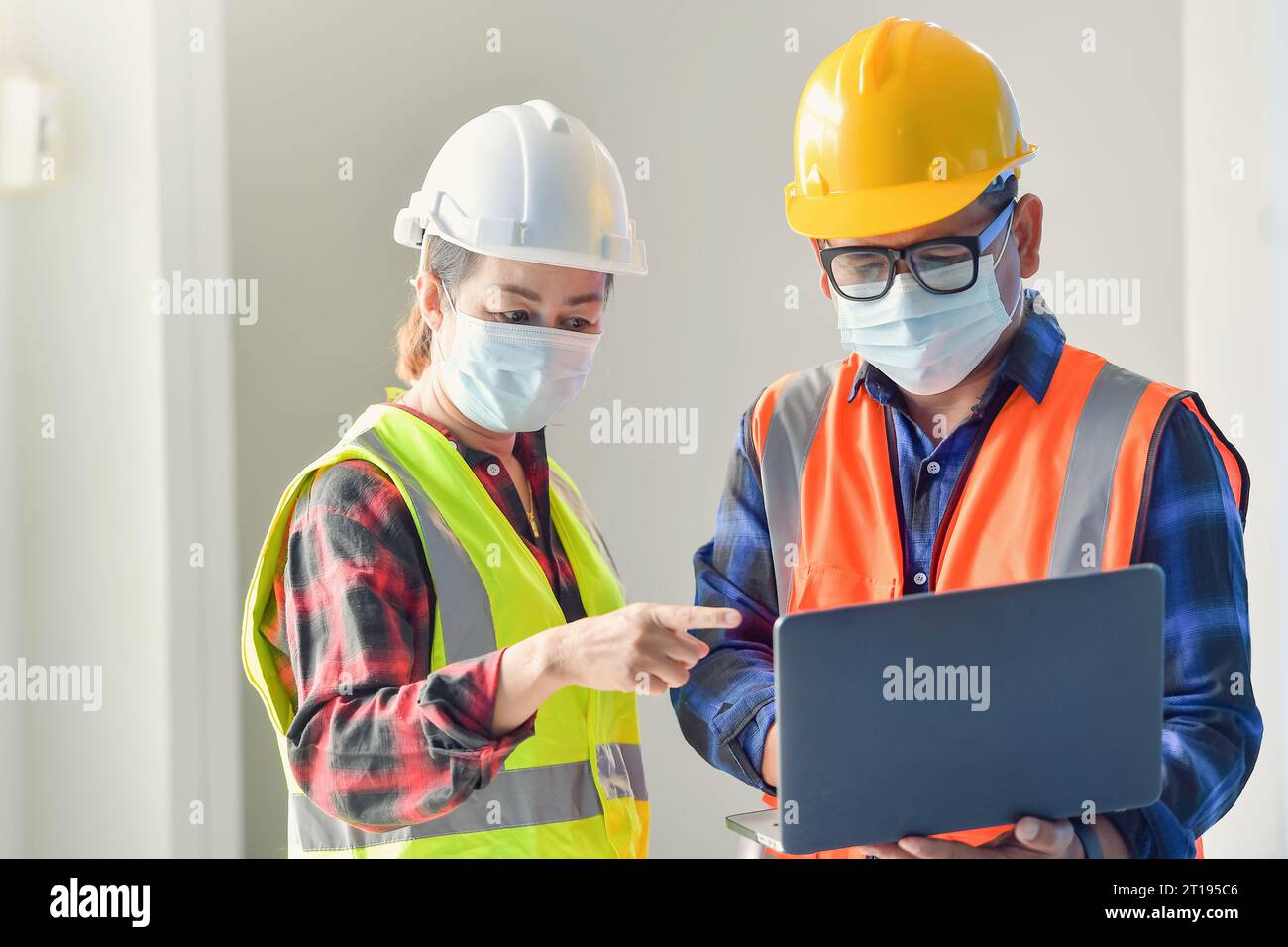 Zwei Bauinspektoren in einem Büro, die ein Bauprojekt diskutieren Stockfoto