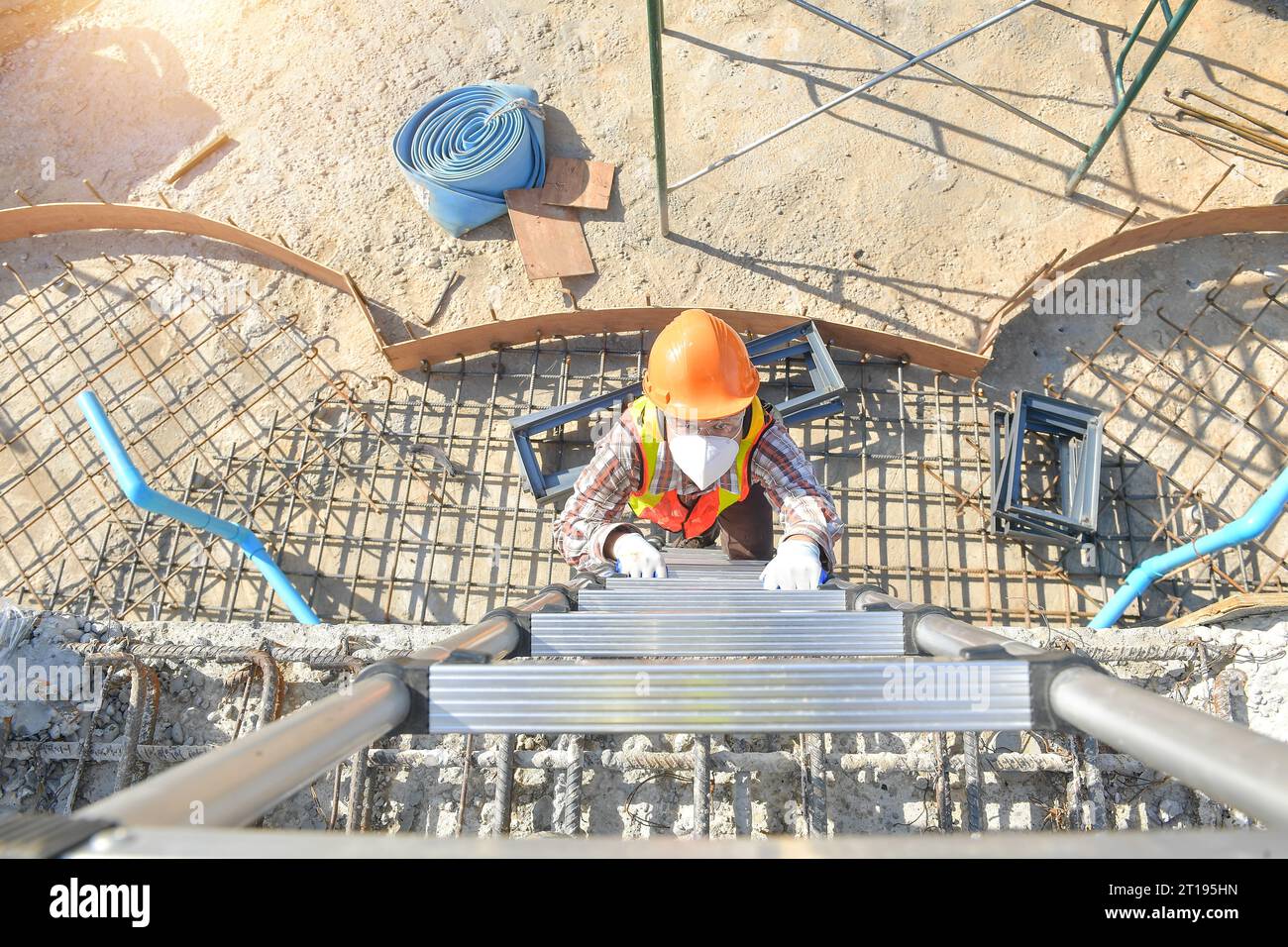 Draufsicht eines Bauarbeiters, der eine Leiter hochklettert, Thailand Stockfoto
