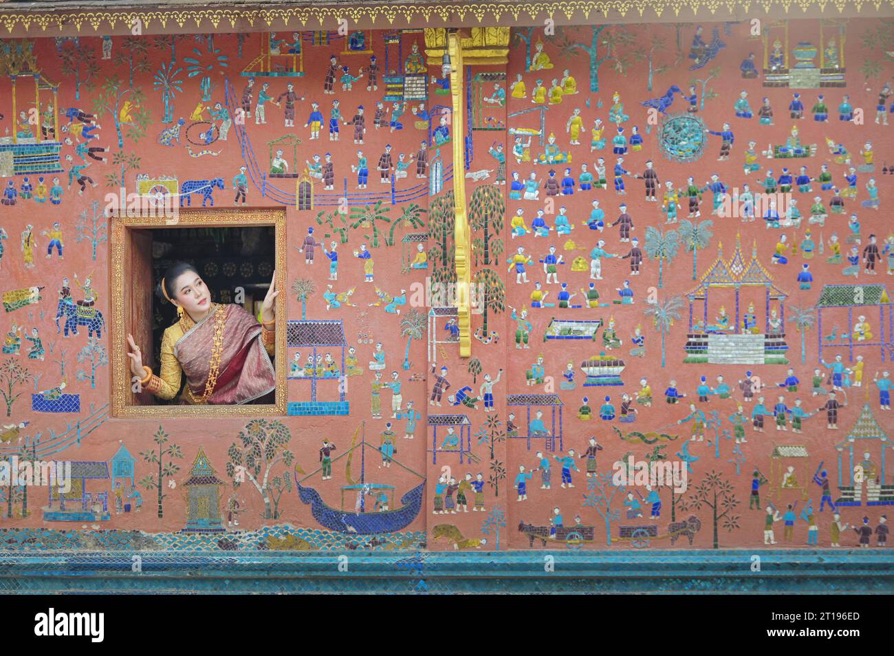 Frau, die aus einem offenen Tempelfenster blickt, Wat Xieng Thong, Luang Prabang, Laos Stockfoto