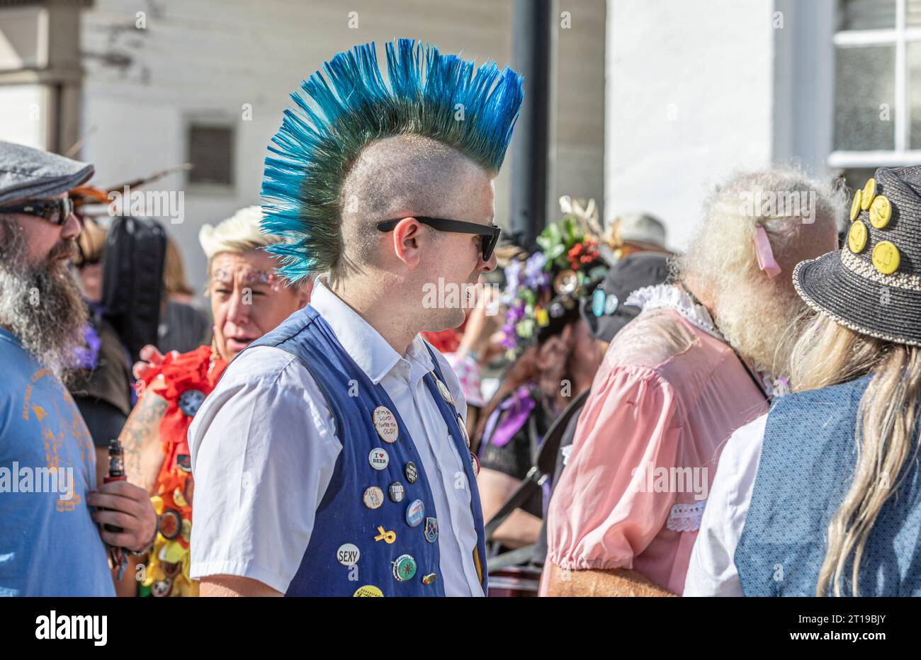 Ein Morris-Tänzer mit blauem Mohican-Haarschnitt auf dem Tenterden Folk Festival, Kent... Stockfoto