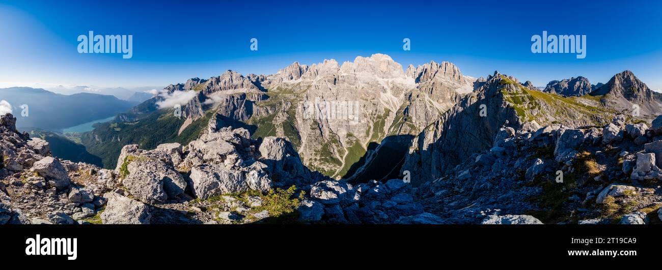 Panoramablick auf Felswände und Gipfel der wichtigsten Brenta-Dolomiten und Molveno-See in der Ferne, vom Croz dell'Altissimo aus gesehen. Stockfoto