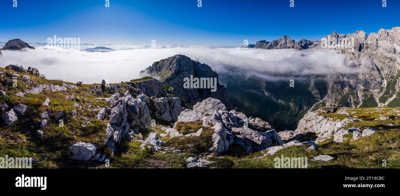 Panoramablick auf das Hauptgebiet der Brenta-Dolomiten und den Gipfel des Croz dell'Altissimo, das nebelbedeckte Tal, von der Cima Sophia aus gesehen. Stockfoto