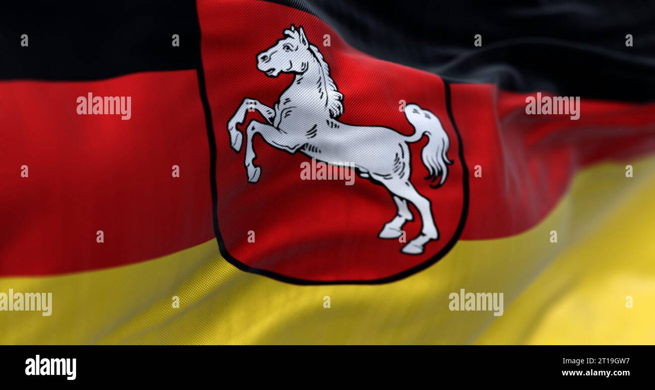 Nahaufnahme der niedersächsischen Landesflagge, die winkt. Schwarze, rote und gelbe Streifen mit Wappen in der Mitte. Deutscher Staat. 3D-Darstellung. Wählen Sie Aus Stockfoto