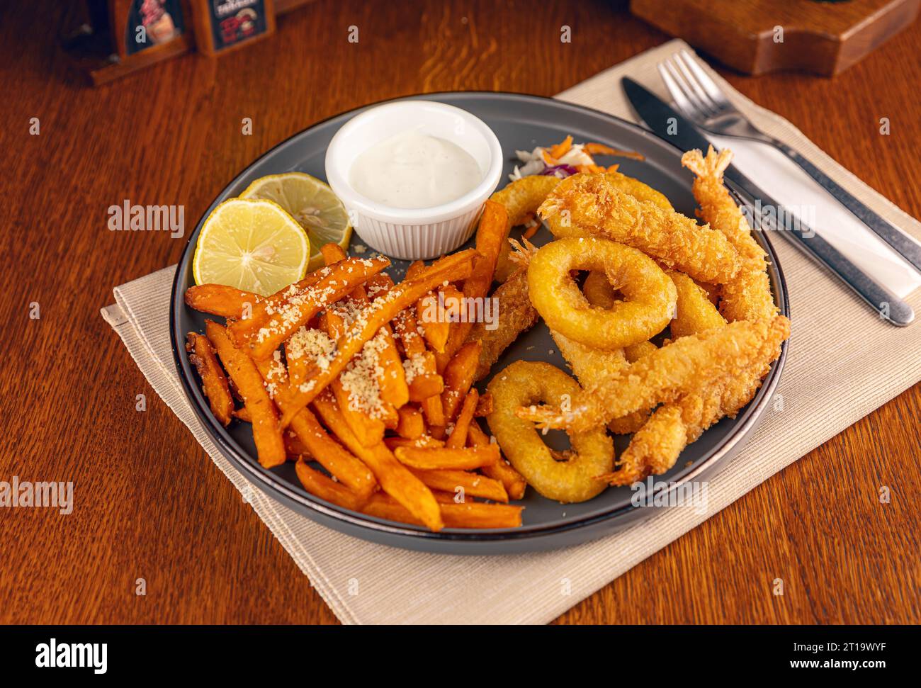 Frittierte Meeresfrüchte, serviert mit Süßkartoffeln und Sauce Stockfoto