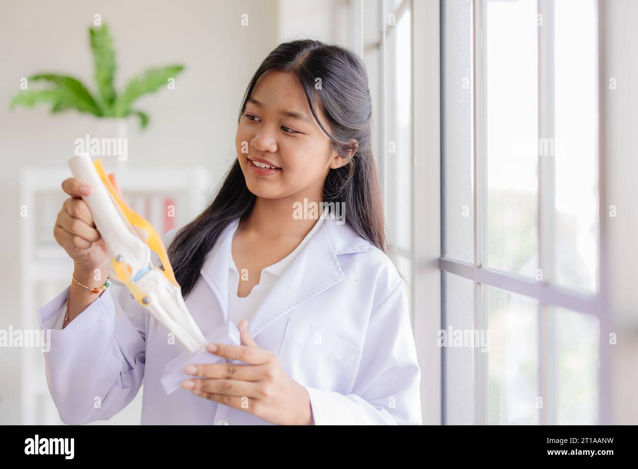 Junger asiatischer Rollenspiel als Arzt, der im Schullabor glücklich lächelt und Platz für Text hat Stockfoto