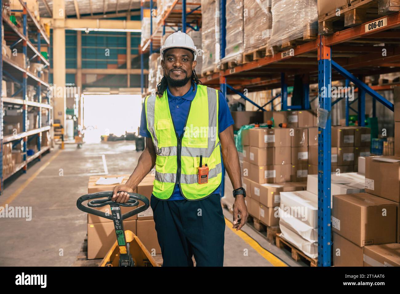 Porträt-Lager Paketzustellung afrikanischer schwarzer männlicher Angestellter glückliches Arbeiten in der Hafenfracht-Schifffahrtsindustrie mit Sicherheitsanzug Stockfoto