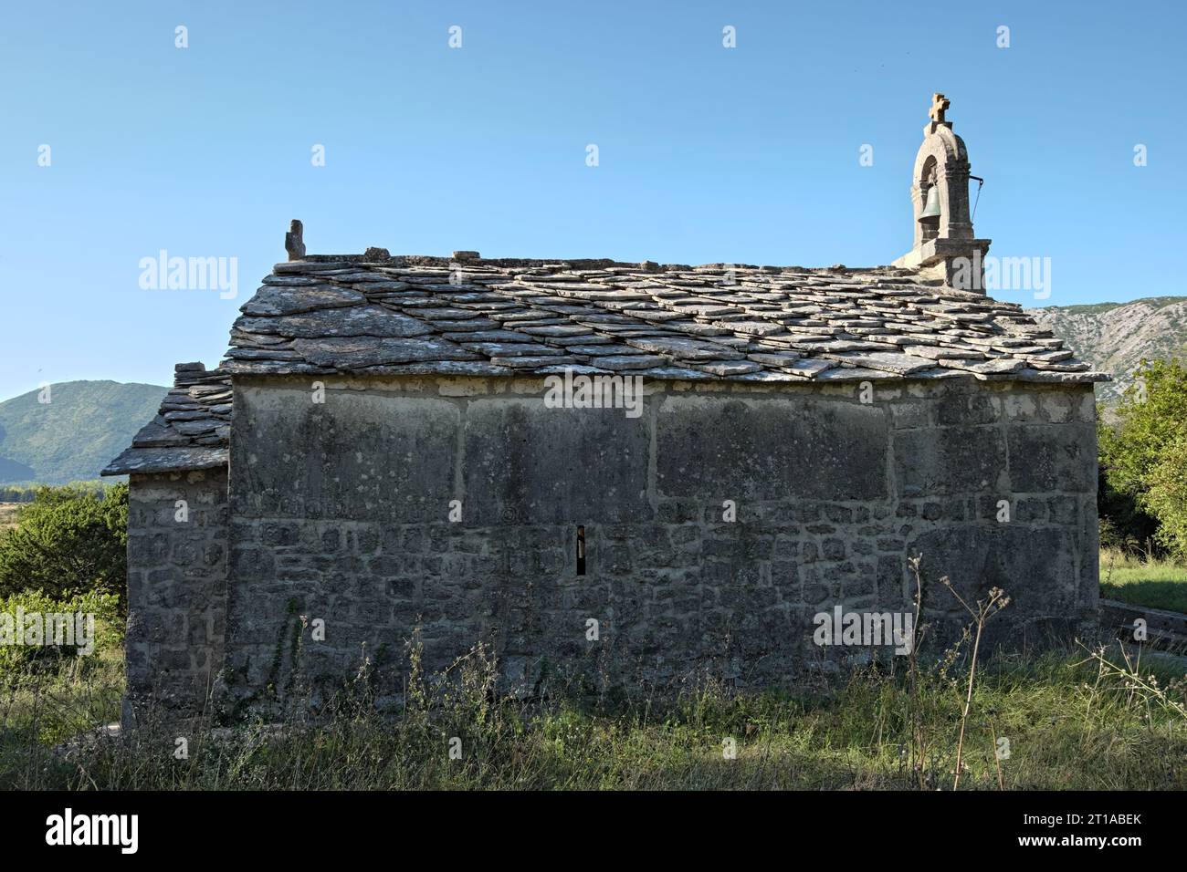 Kleine Steinkirche mit großen Grabsteinen, genannt „stecci“ in Bosnien und Herzegowina Stockfoto