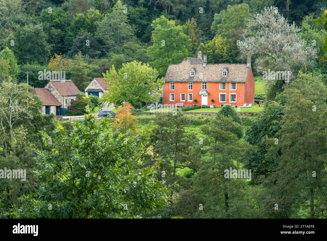 Altes hübsches, terrakottafarbenes Bauernhaus umgeben von Bäumen, Holwell Farm, Ozleworth Bottom, Wotton Under Edge, Gloucestershire, England, Großbritannien Stockfoto