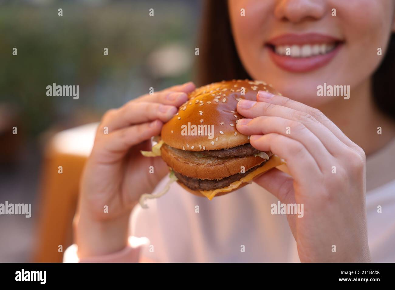 Lviv, Ukraine - 26. September 2023: Frau isst McDonald's Burger im Freien, Nahaufnahme. Leerzeichen für Text Stockfoto