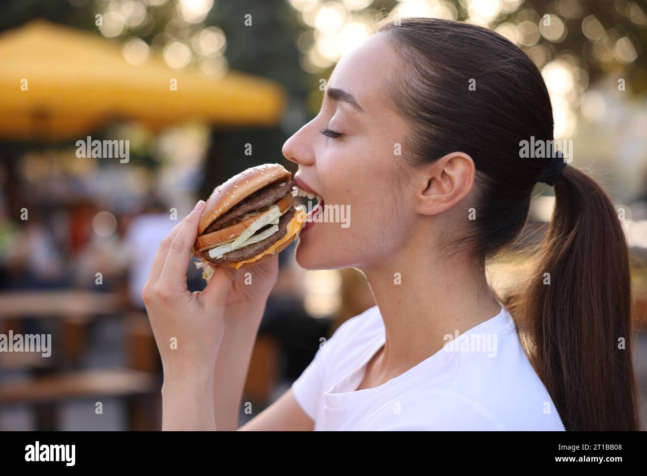 Lviv, Ukraine - 26. September 2023: Frau isst McDonald's Burger im Freien Stockfoto