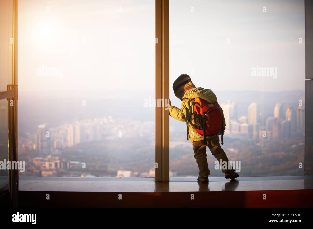 Kleiner Junge, der auf einem Dach eines Wolkenkratzers läuft Stockfoto