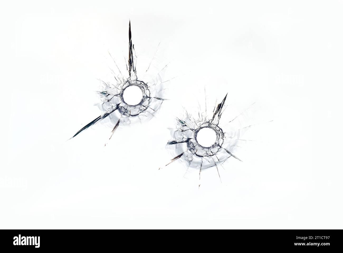 Zwei Kugellöcher im Glas auf weißem Hintergrund. Stockfoto