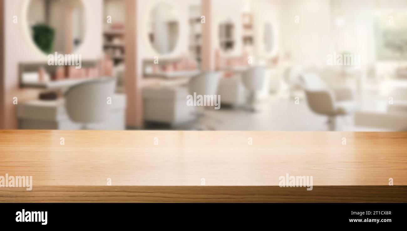 Leere braune Holztischplatte für Produktpräsentation auf verschwommenem Schönheits- und Friseursalon-Innenhintergrund Stockfoto