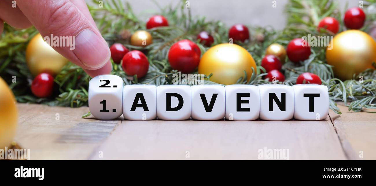 Die Hand dreht Würfel und ändert den Ausdruck '1. Advent“ auf „2. Advent“. Stockfoto