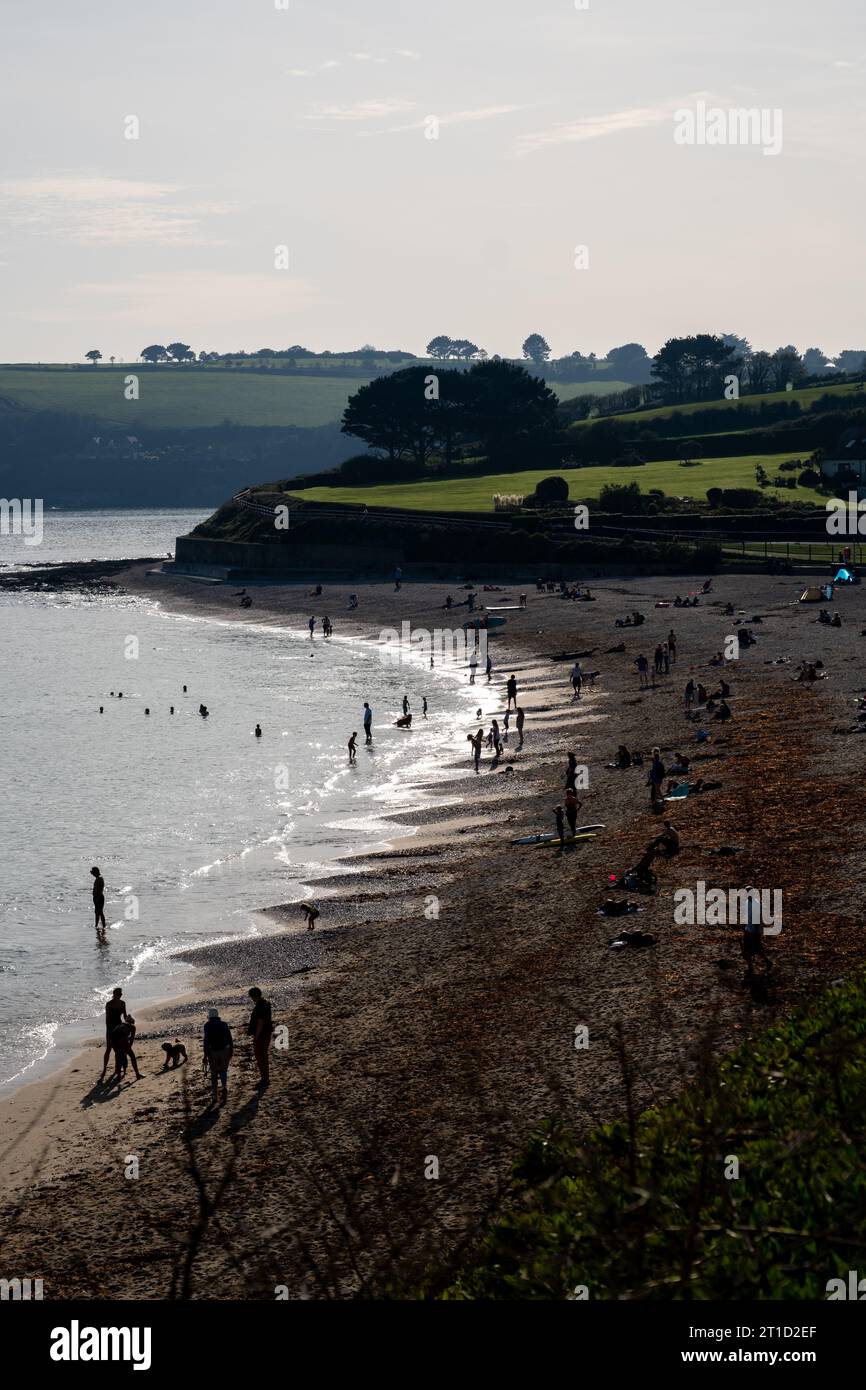 Silhouetten von Menschen, die die Herbstsonne am Gyllyngvase Beach, Falmouth, Großbritannien, genießen Stockfoto