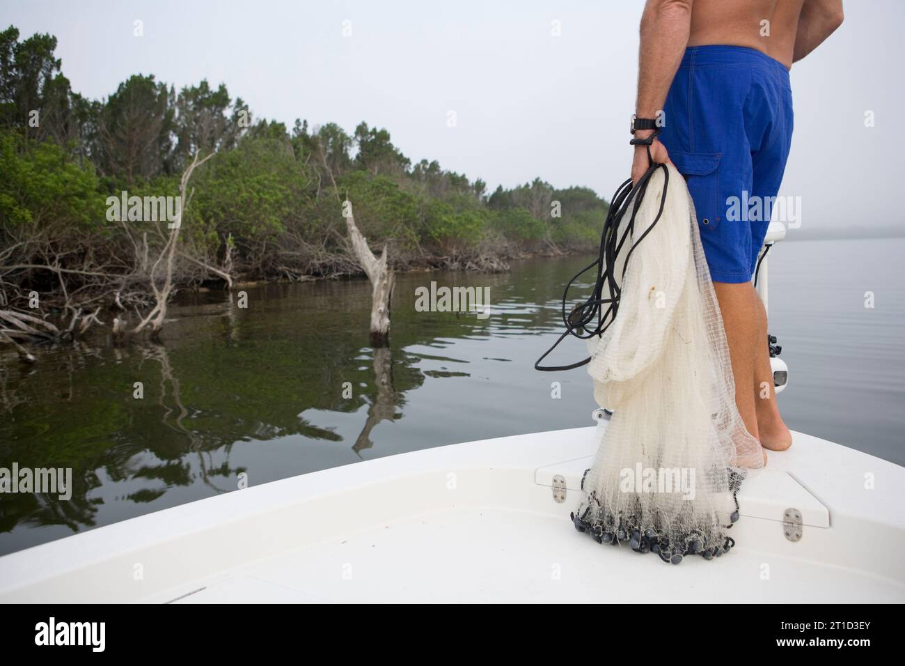 Ein Fischer will mit seinem Netz Köderfische fangen. Stockfoto