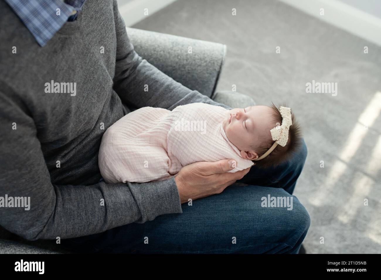 Schlafendes, gewickeltes Kind in Vaters Armen; Bild über dem Kopf Stockfoto