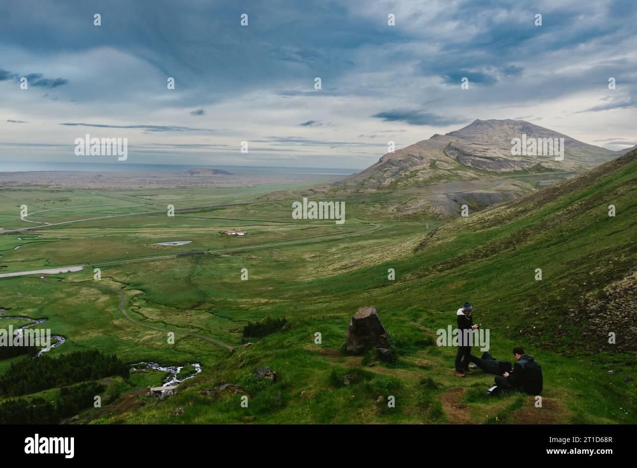 Die Menschen wandern auf grünen Hügeln über das Tal in Bergen mit Wolken Stockfoto