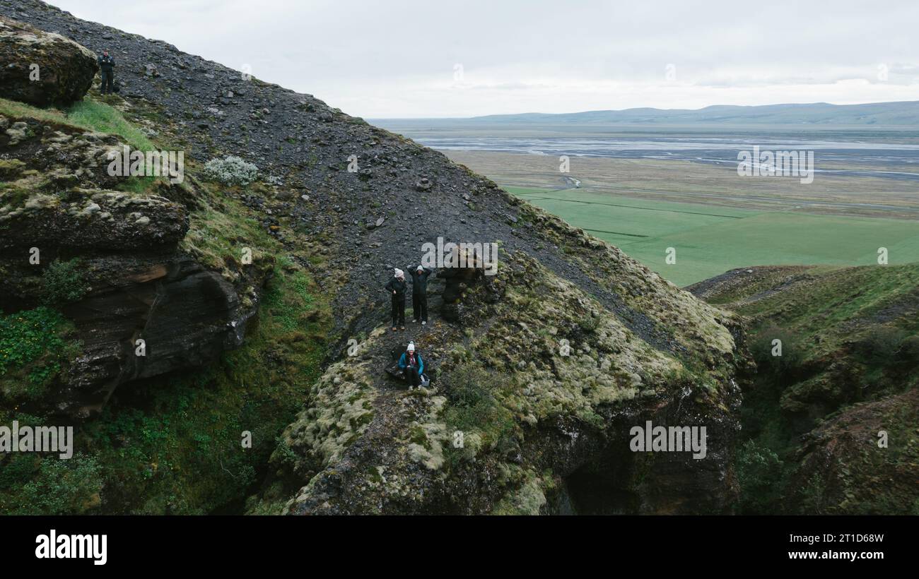 Die Menschen wandern auf einem Berg über einem Tal aus Grün und Wolken Stockfoto