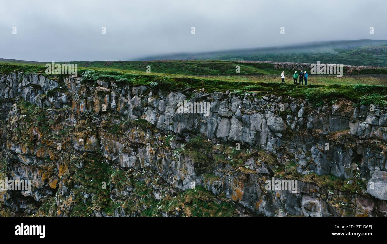 Die Menschen wandern auf grünen Hügelklippen über Felsen und reisen und spazieren Stockfoto