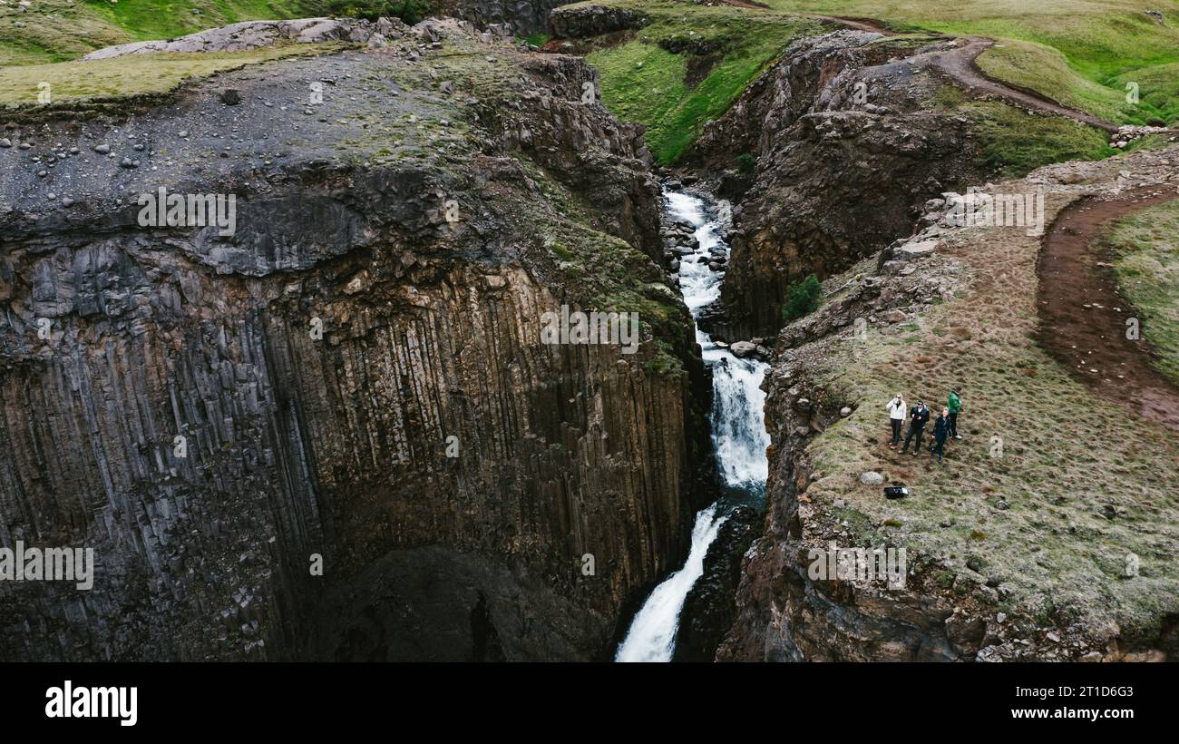 Menschen am Rande der Basaltklippe mit Flüssen und Wasserfällen Stockfoto