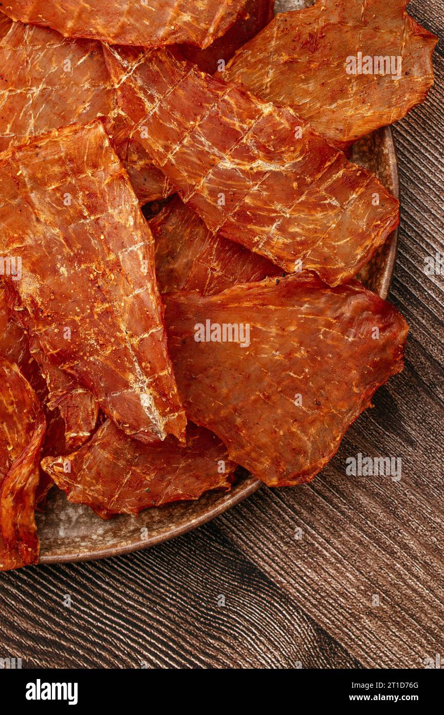 Snack für Bier. Räucherfleisch-Chips mit Gewürzen auf grauer Platte. Stockfoto