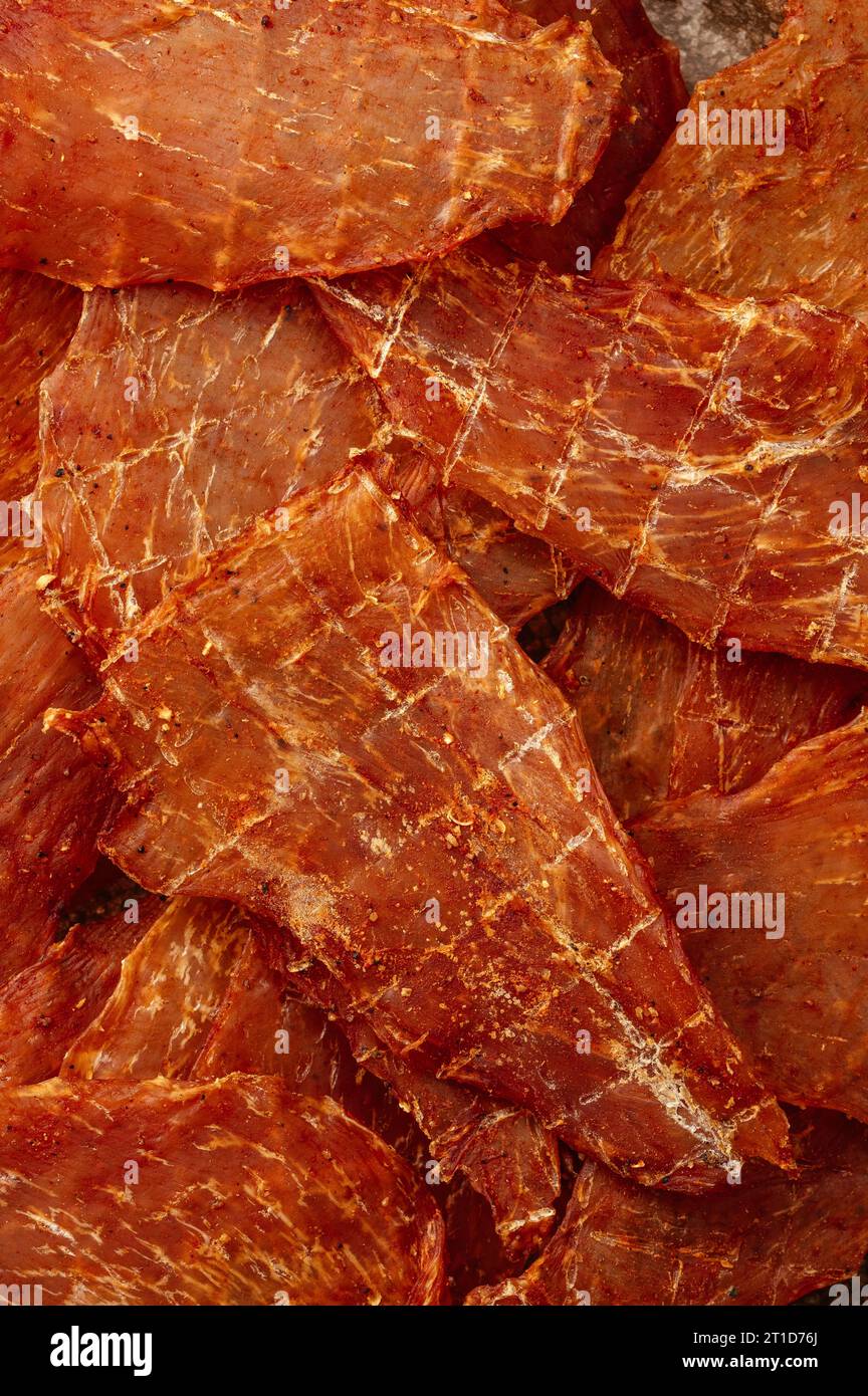 Snack für Bier. Räucherfleisch-Chips mit Gewürzen auf grauer Platte. Stockfoto