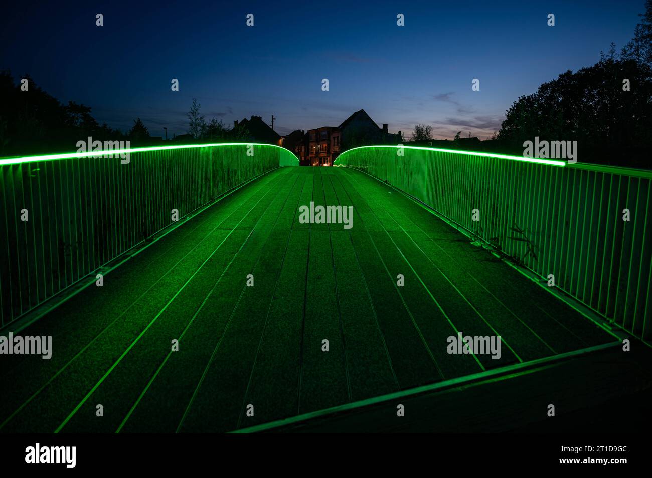 Liedekerke, Ostflämische Region, Belgien, 1. Oktober, 2023 - Nachtblick über die Fußgängerbrücke mit grünen Lichtern am Bahnhof, Stockfoto