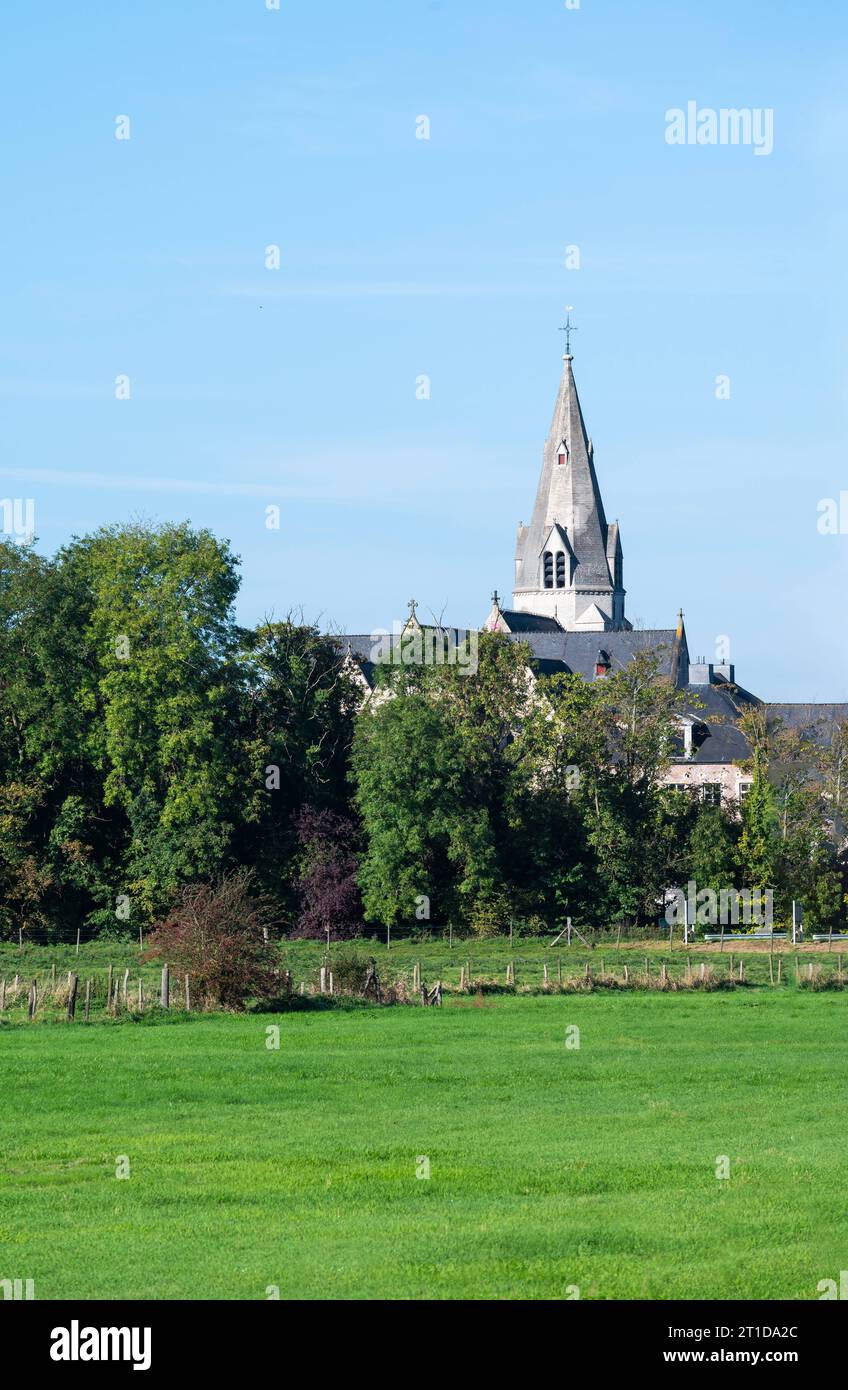 Grüne Felder und Bäume mit dem Kirchturm im Hintergrund rund um Liedekerke, Ostflämische Region, Belgien Credit: Imago/Alamy Live News Stockfoto