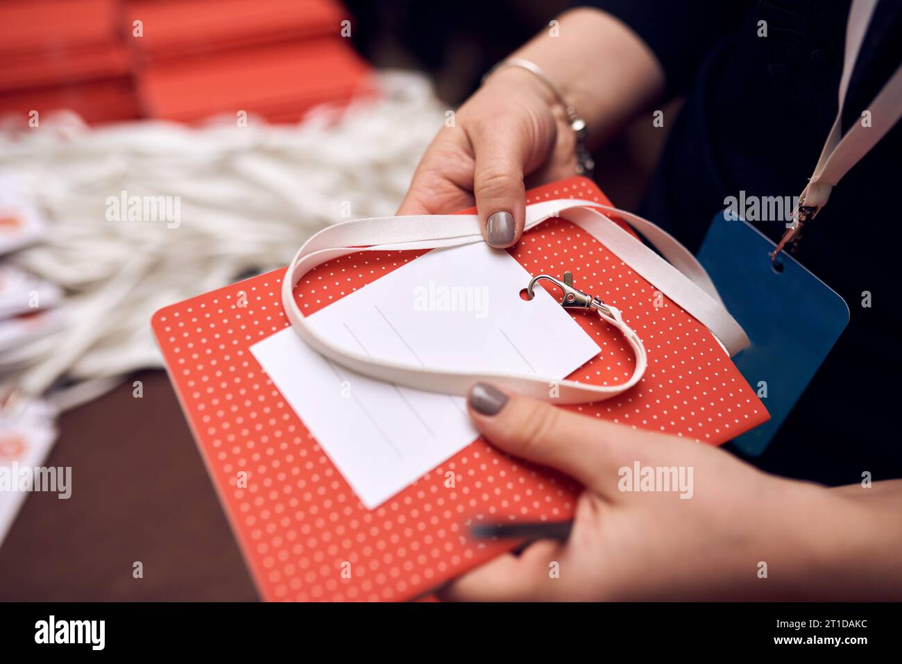 Prozess des Eincheckens bei Veranstaltung des Kongressforums, bei der Registrierung, bei Besuchern und Teilnehmern, die ein Namensschild erhalten. Stockfoto