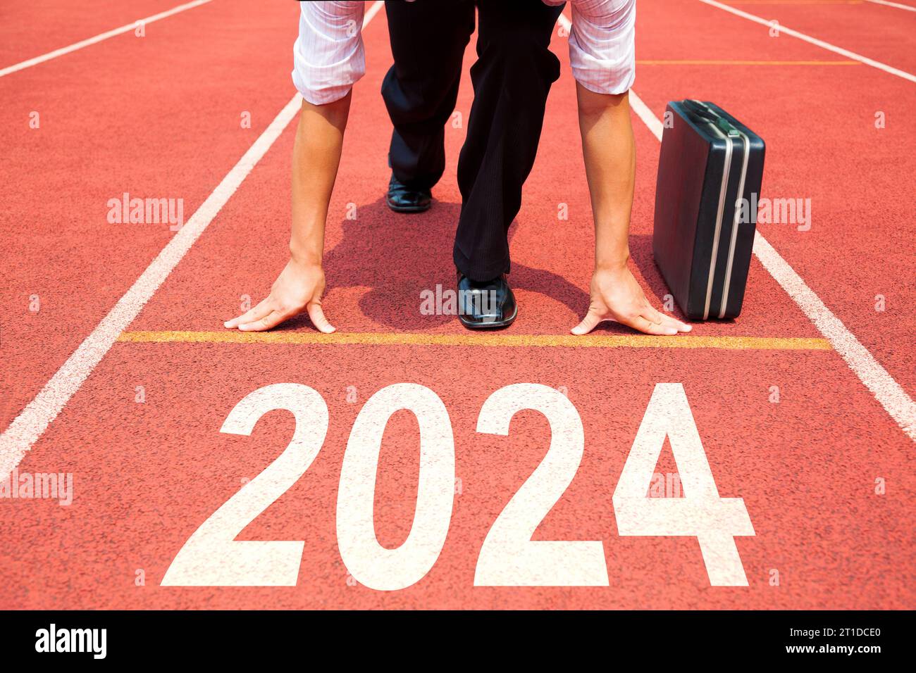 Geschäftsmann bereit für Lauf und Sprint auf der Strecke mit 2024 Erfolgskonzept Stockfoto