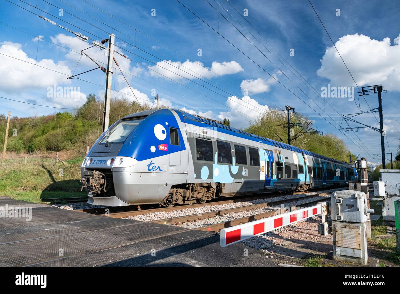 Durchfahrt eines TER-Zuges durch einen Bahnübergang zwischen Paris, Rouen und Le Havre in Le Houlme (Normandie, Nordfrankreich) Stockfoto