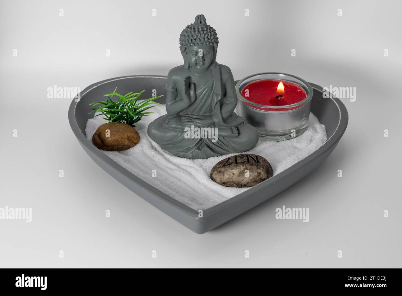 Zen-Garten. Spirituelle Buddha-Dekoration für eine ruhige, ruhige und konzentrierte Atmosphäre. Kerze, die Aromen in einer entspannenden Oase freisetzt. Stockfoto