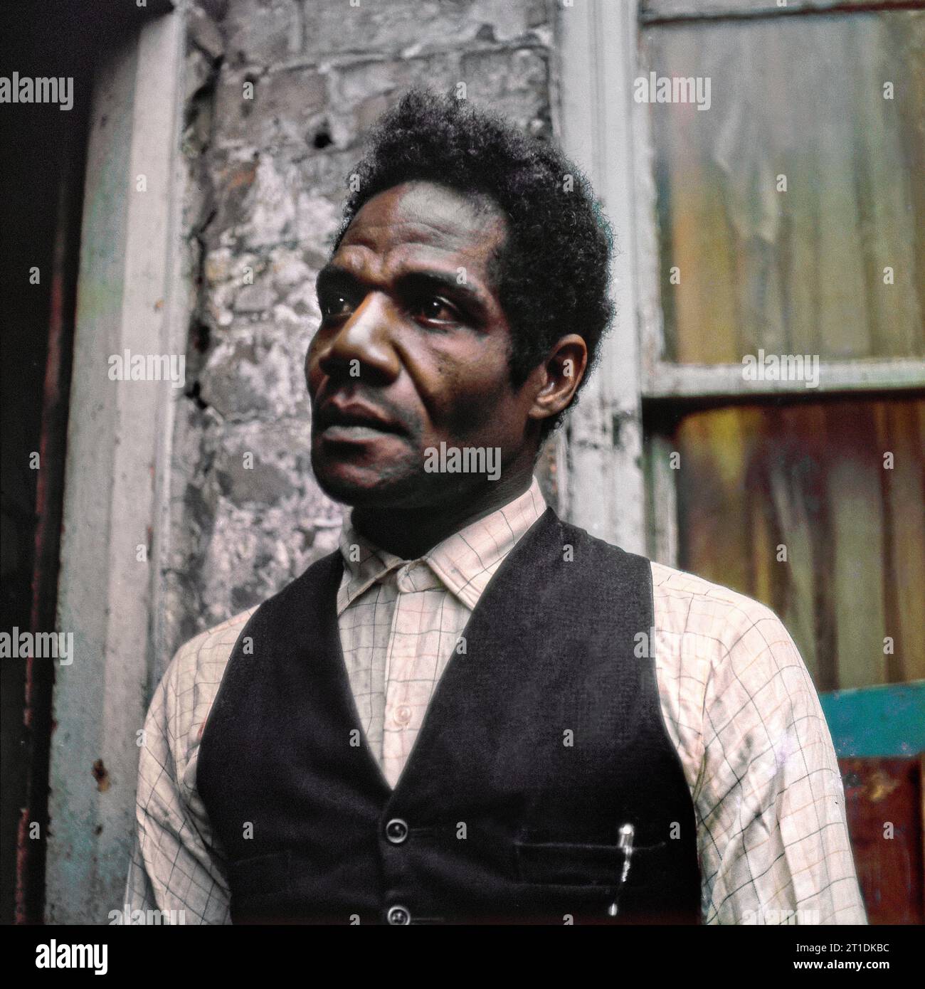 Der schwarze Mann stand während der Räumung und des Abbruchs des Slums in St. Ann's, Nottingham, England, in der Eingangstür seines viktorianischen Reihenhauses. 1969-1972 Stockfoto