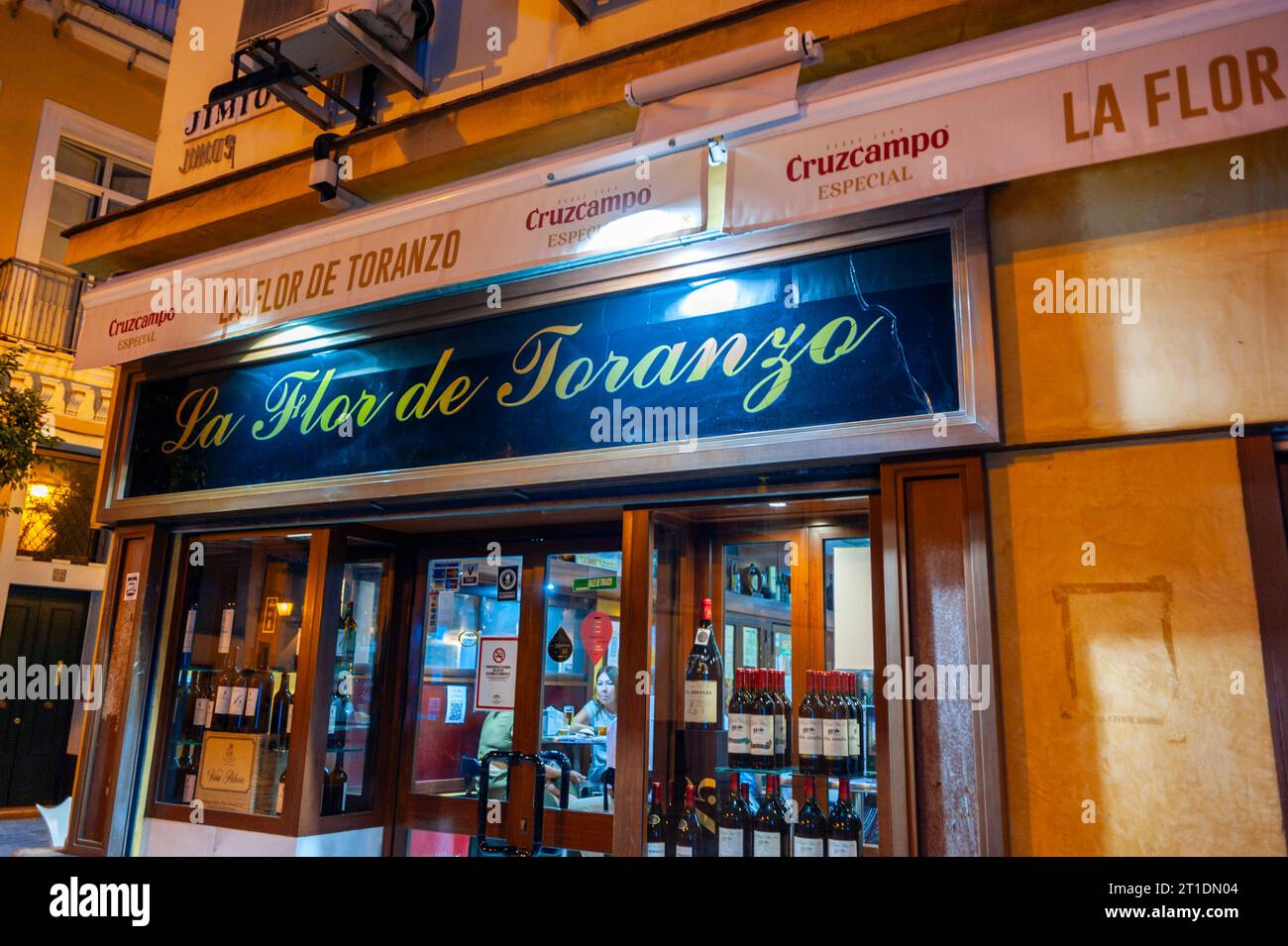 Sevilla, Spanien, Frontansicht, Straßenansichten im Freien, Spanisches Bistro-Restaurant, bei Nacht, im Zentrum der Altstadt, „La Flor de Toranzo“ Eingangsschild Stockfoto