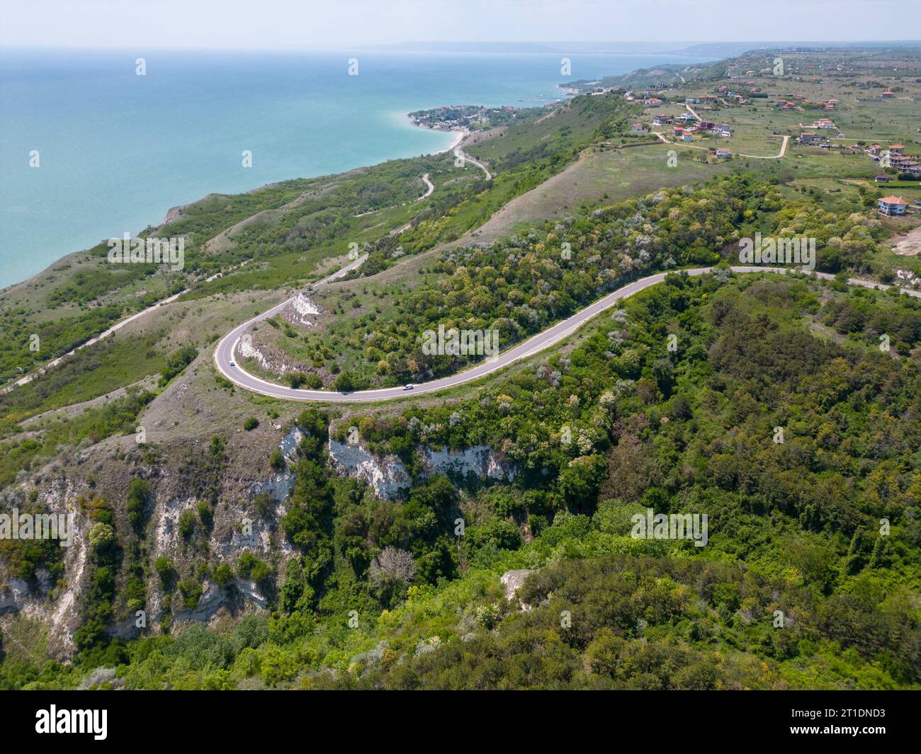 Eine gewundene Straße schlängelt sich durch malerische Wiesen und bezaubernde Wälder und bietet eine malerische Reise in die Nähe der faszinierenden Küste. Die Natur Stockfoto