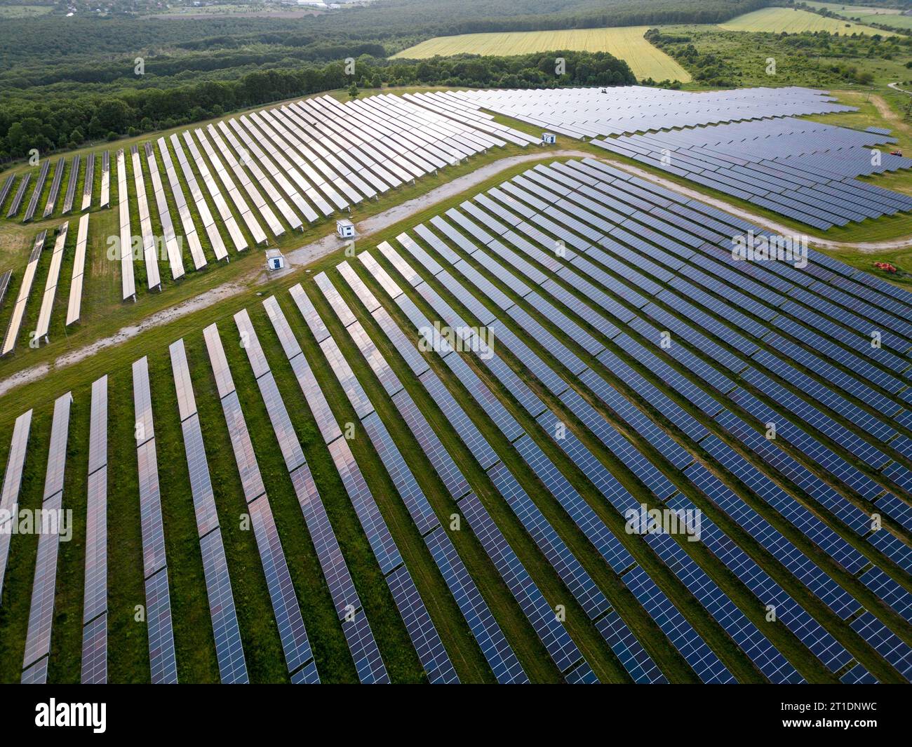 Großes Solarkraftwerk auf einer grünen Wiese von oben Stockfoto